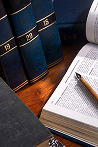 A set of encyclopedias with one open on a desk.