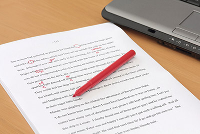 A typed paper with red pen mark editing on it.