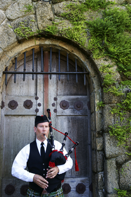 A man playing the bagpipes.
