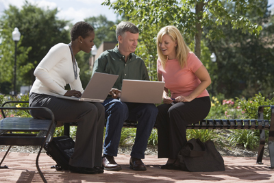 A picture of three adult students comparing notes.