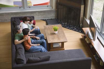 A picture of a family watching TV together.